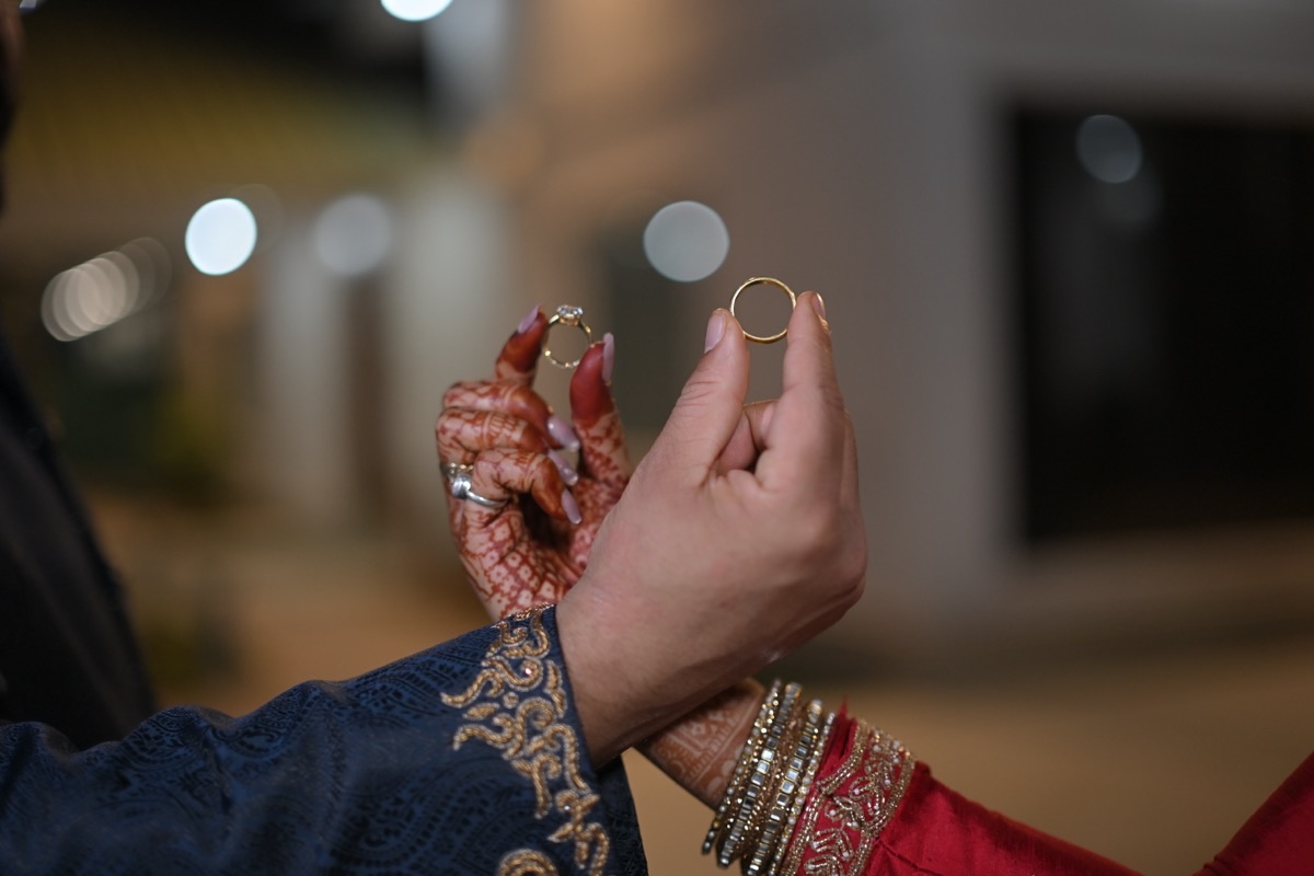 Rahul and Kashish holding their wedding rings